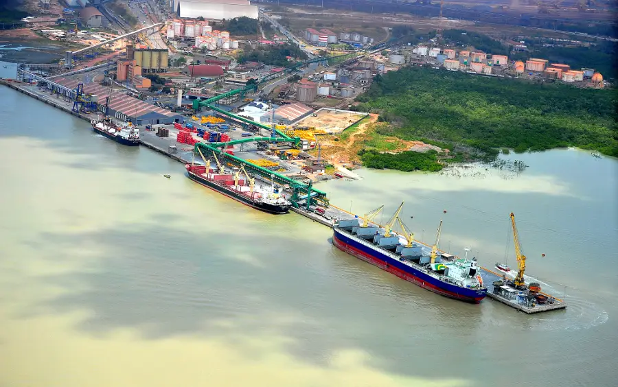 Aerial view of a busy Brazilian port with large cargo ships docked alongside cranes and cargo handling equipment