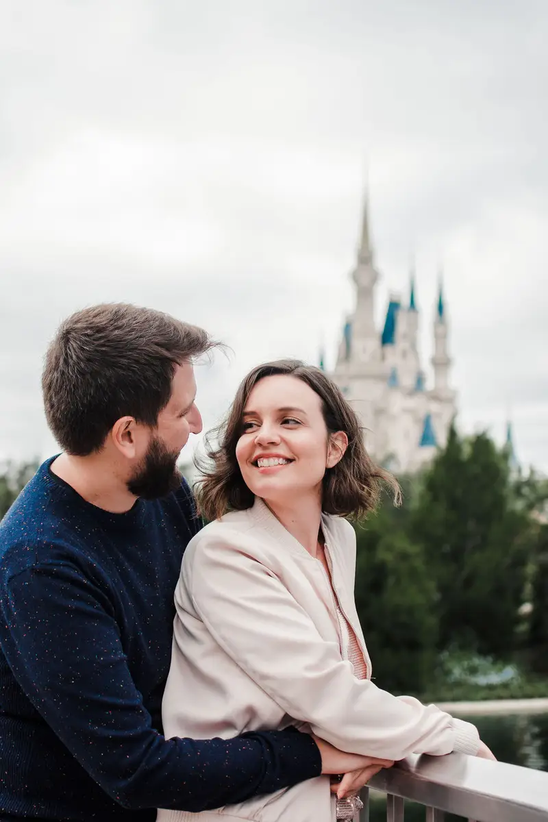 Casal feliz abraçado com castelo da Disney ao fundo