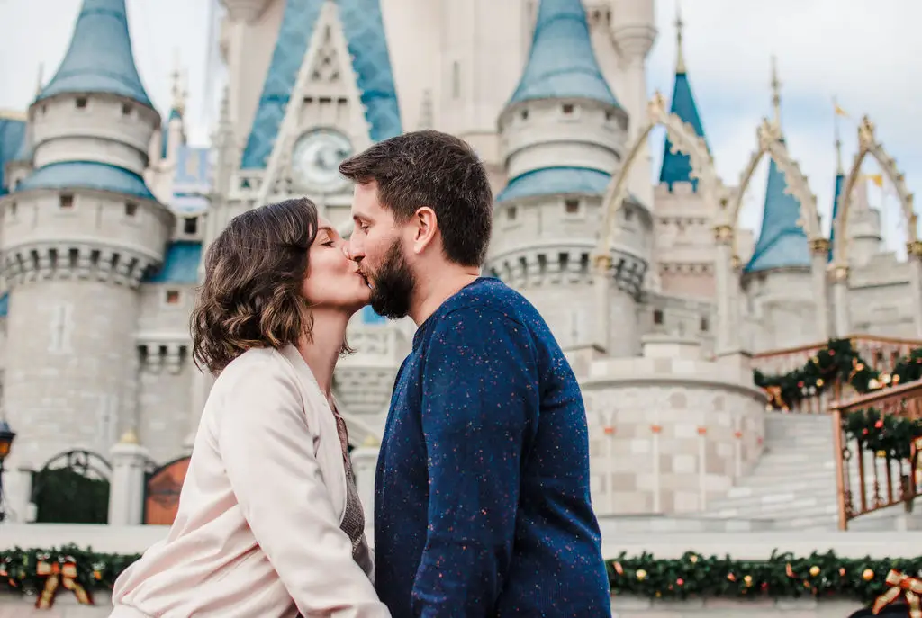 Casal se beijando em frente ao castelo da Cinderella na Disney