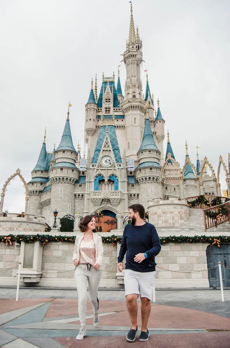 Casal sorridente caminhando em frente ao castelo da Cinderela na Disney em Orlando