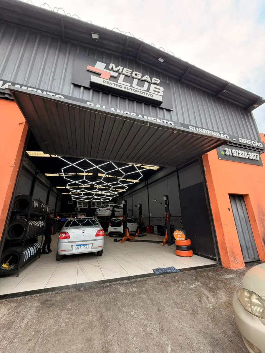 Entrada da oficina Megap Lub Auto Center com carros em manutenção e pneus empilhados