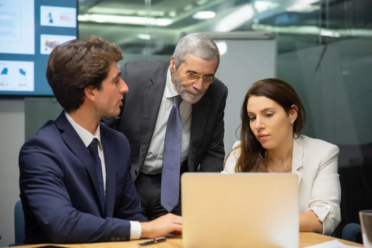 Equipe de negócios analisando informações em laptop durante reunião