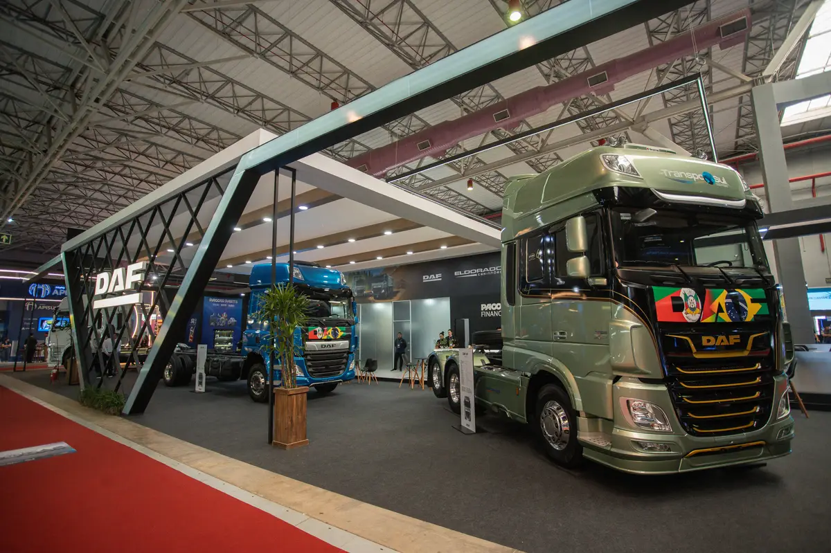 Caminhões DAF expostos em estande moderno e espaçoso com estrutura metálica e iluminação interna