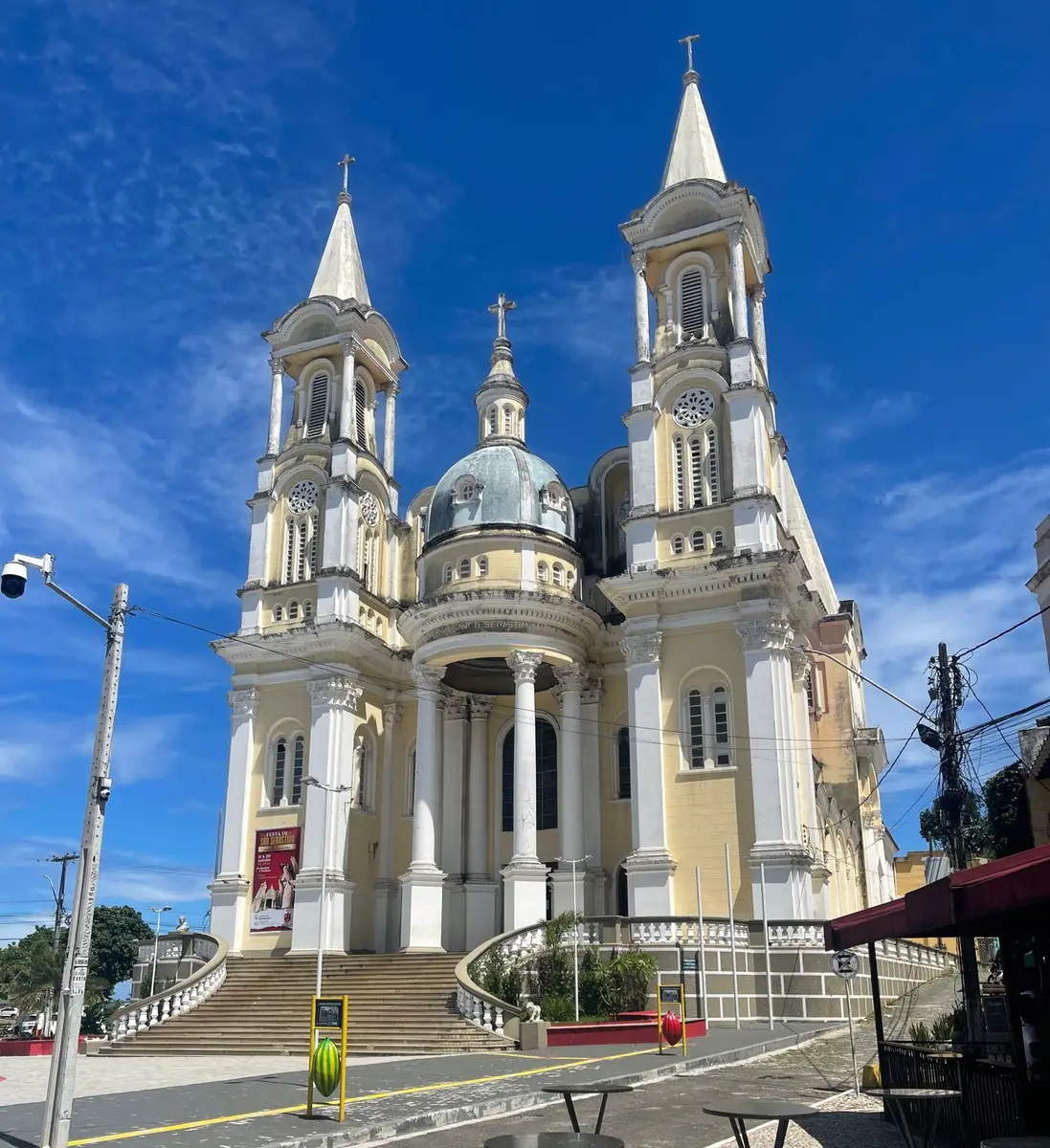 Igreja histórica de São Sebastião com duas torres pontiagudas sob céu azul