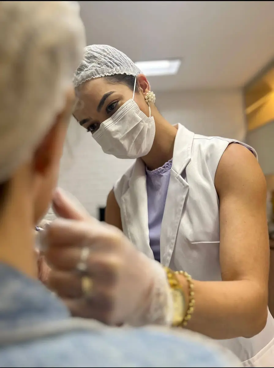 Médica avaliando o rosto de paciente para tratamentos faciais