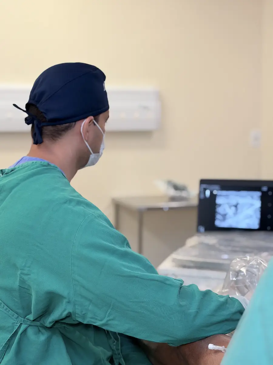 Médico vascular realizando exame com ultrassom em paciente na clínica