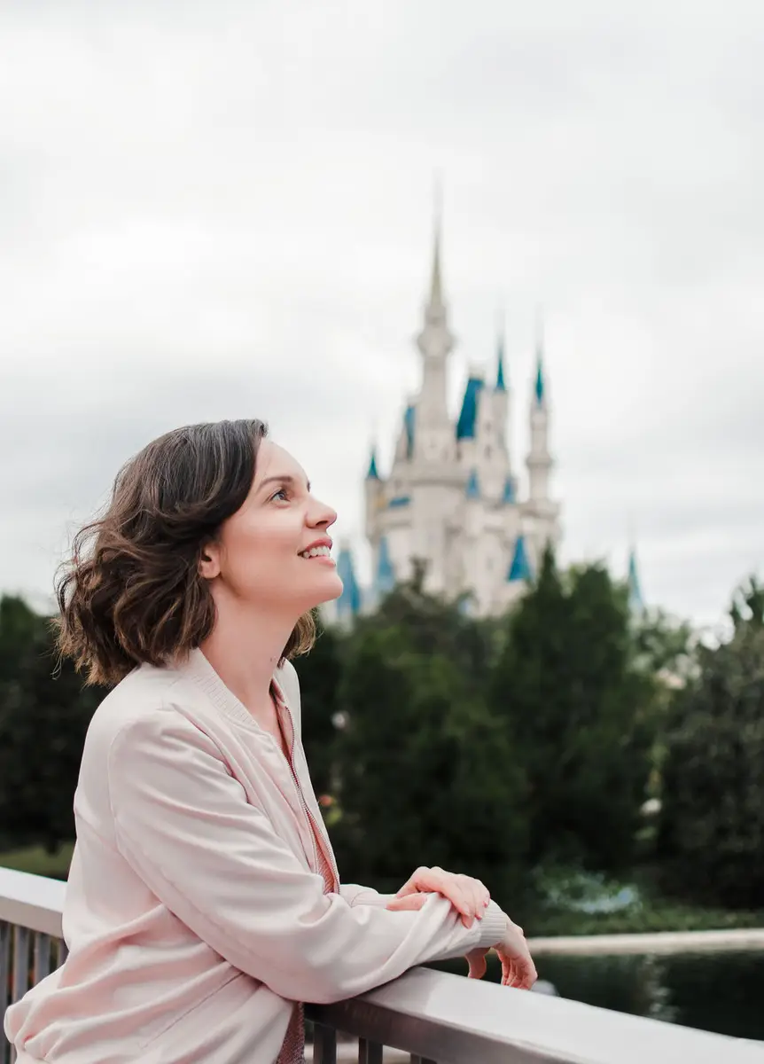 Mulher sorridente olhando para o castelo da Disney em Orlando