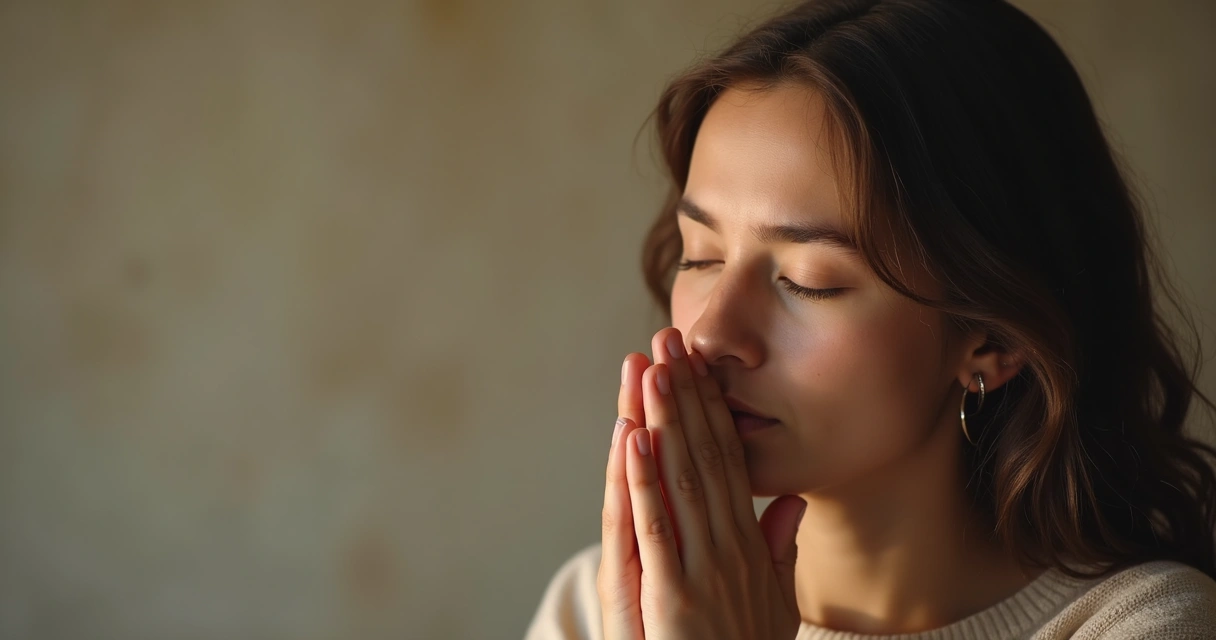 Mulher com olhos fechados e mãos em oração, expressão serena 