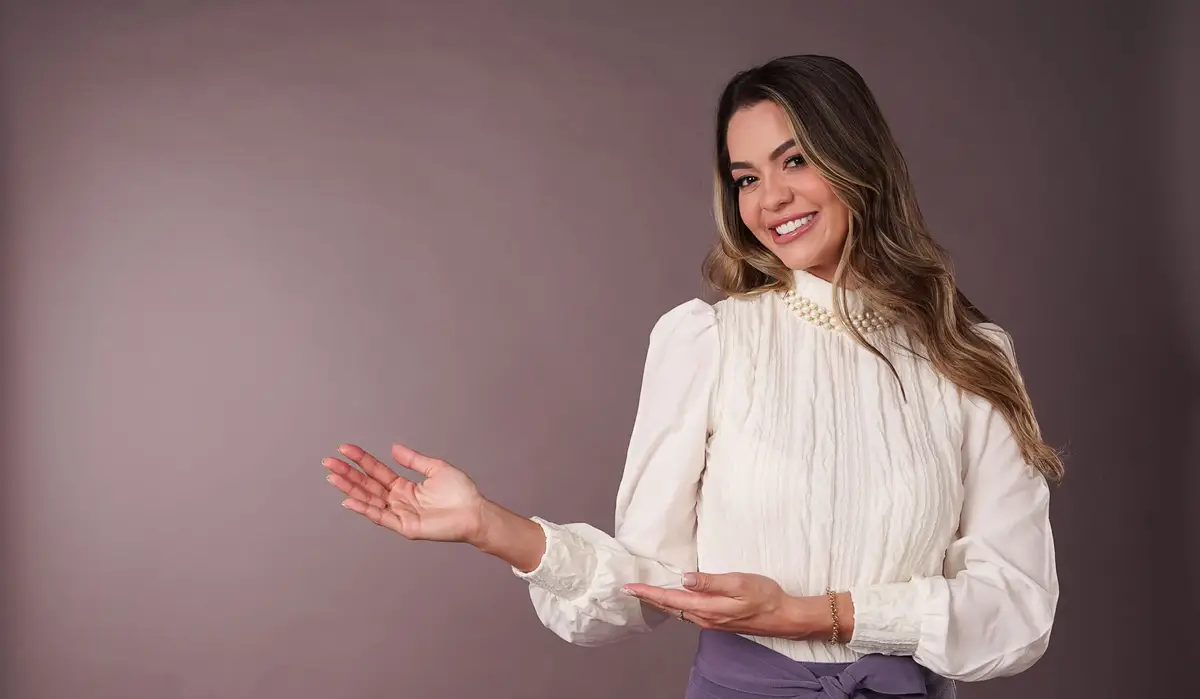 Mulher sorridente apontando para o lado esquerdo com a mão