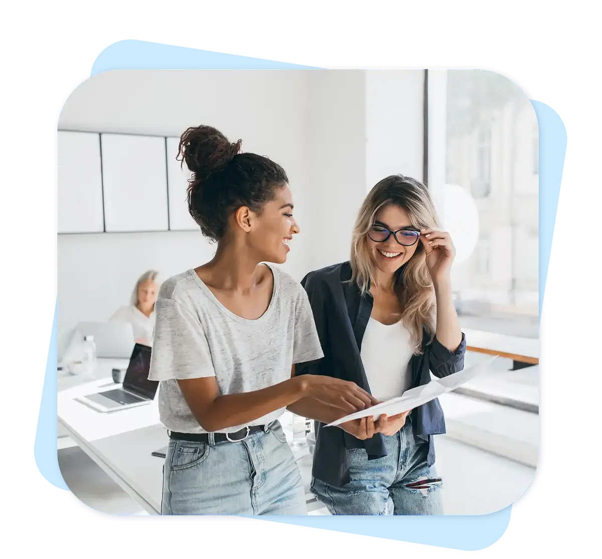 Duas mulheres conversando e analisando documentos em escritório moderno e iluminado