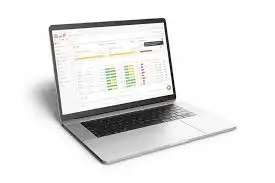 Notebook aberto mostrando software de gestão com tabelas de vendas e indicadores financeiros coloridos