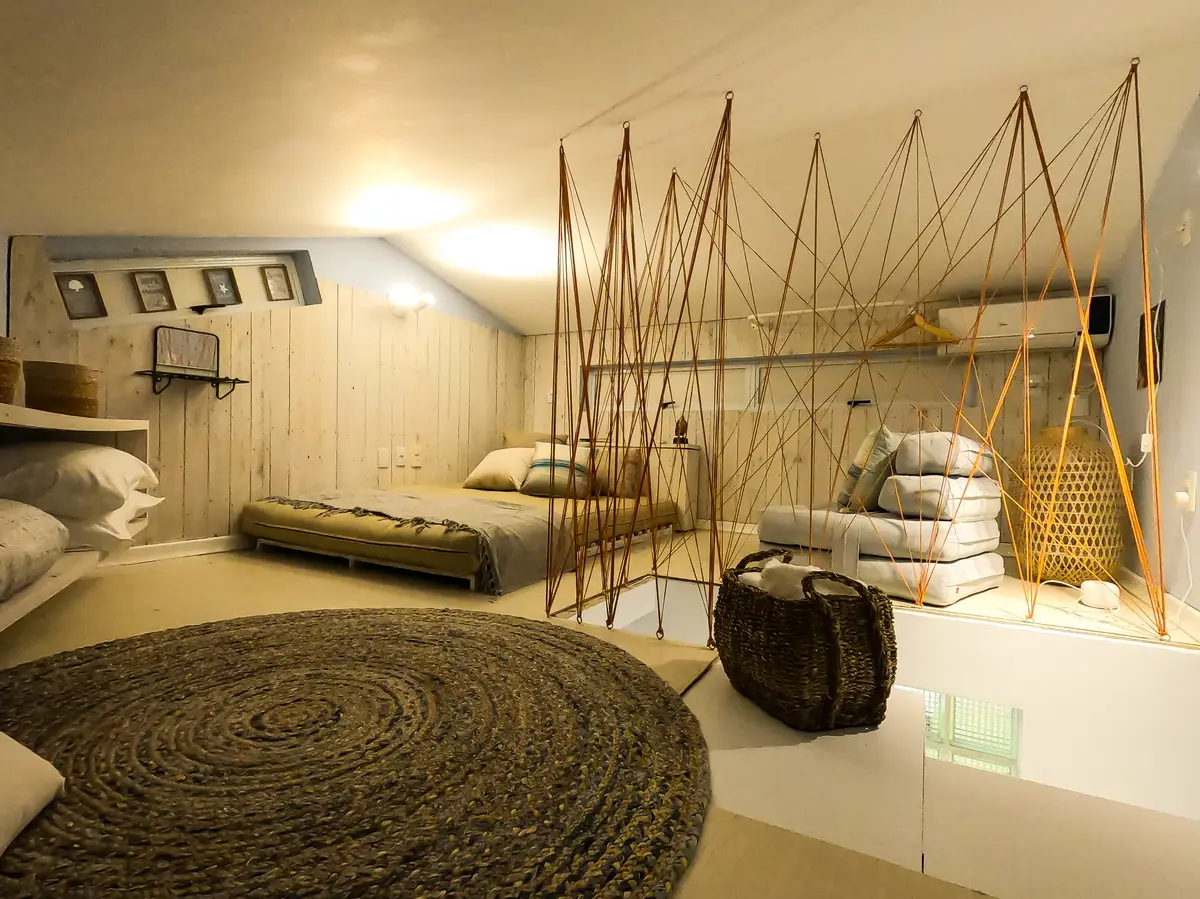 Quarto aconchegante com cama baixa, tapete redondo de fibras naturais e decoração rústica