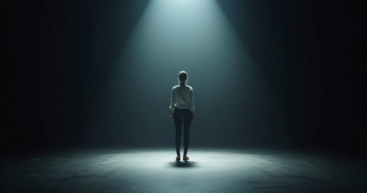 Woman standing alone on a stage with a spotlight 