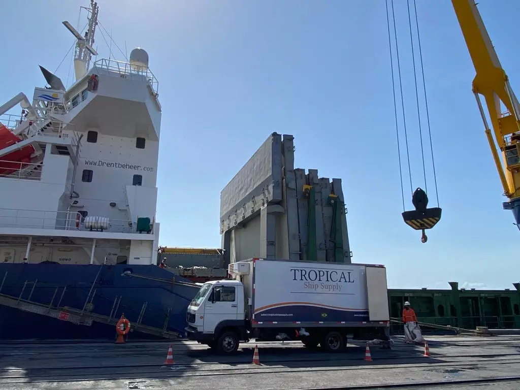 Tropical Ship Supply truck unloading supplies to a large ship at port