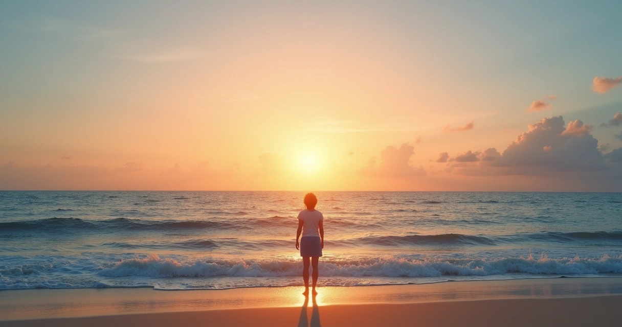 Person standing by the sea at sunset looking at the horizon 